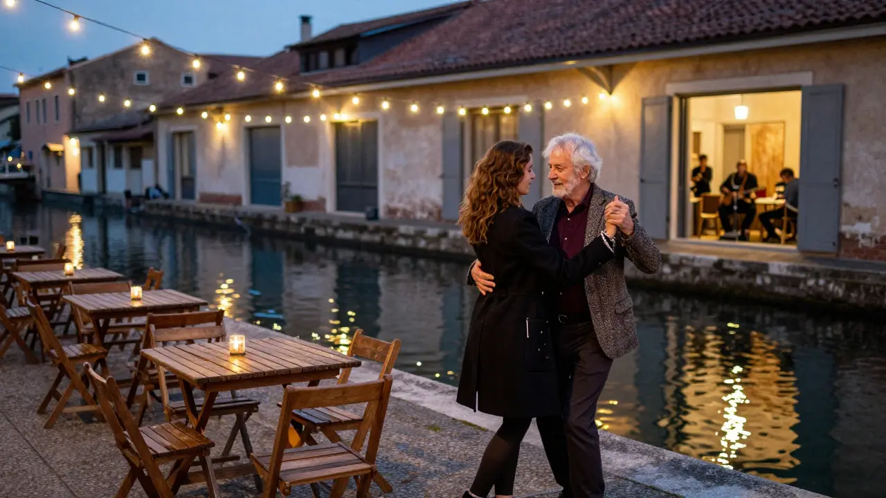 An older man and young woman dancing together by a canal under string lights at night.